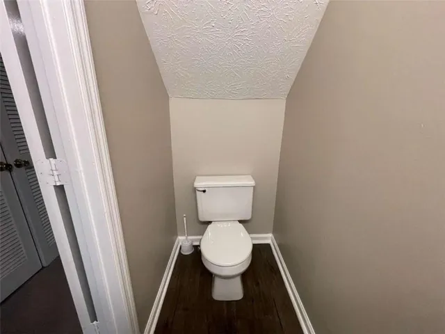 a white toilet sitting in a bathroom next to a sink