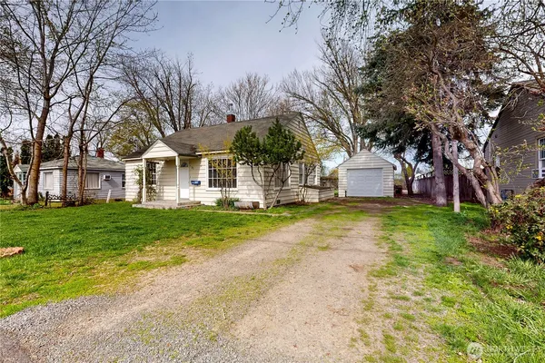 a view of house with backyard and tree
