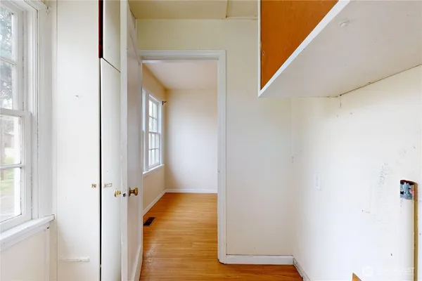 a view of a hallway with wooden floor and staircase