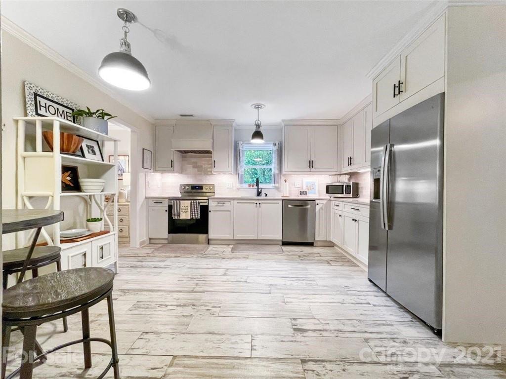 733 Neill Ridge Road Matthews, NC 28105 - Photo 7 of 30 a large kitchen with cabinets wooden floor and stainless steel appliances