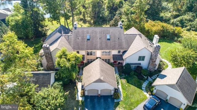 an aerial view of a house with a yard and large trees