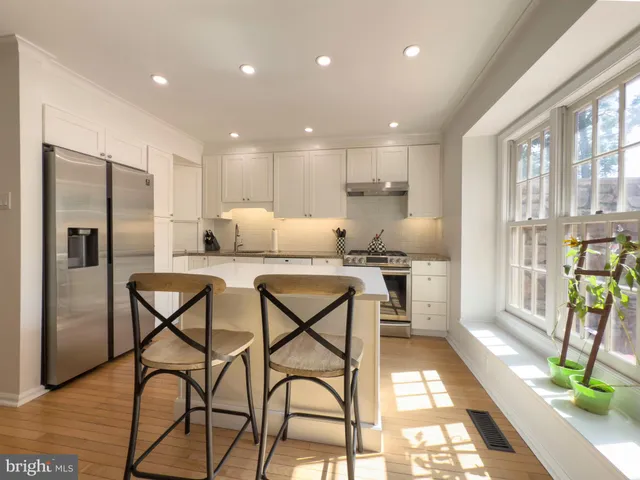 a kitchen with stainless steel appliances kitchen island granite countertop a refrigerator and microwave