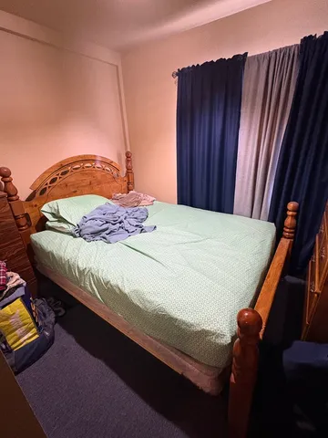 a bed room with two bed and a chair