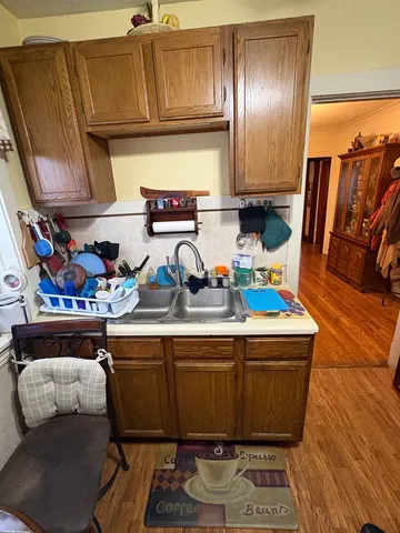 a kitchen with a sink a stove and a wooden floor