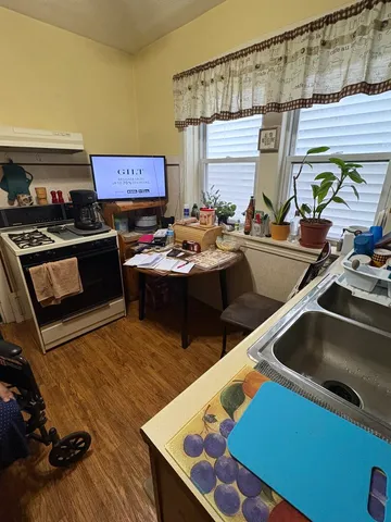 a view of a dining room with furniture a chandelier and wooden floor