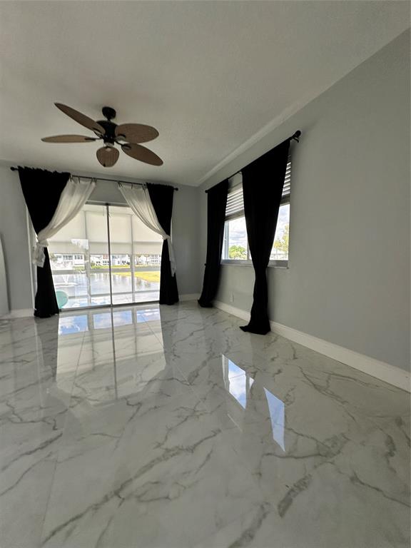 2701 East Golf Boulevard, Unit 2017 Pompano Beach, FL 33064 - Photo 12 of 26 an empty room with windows and fan