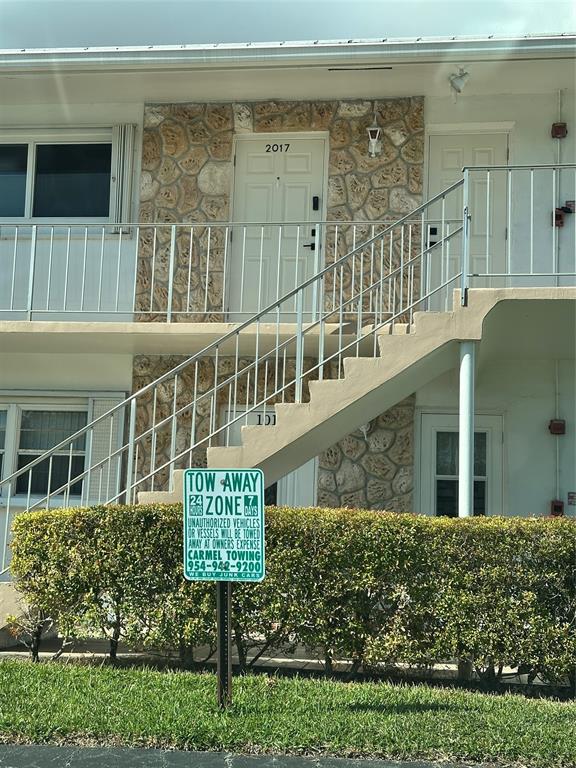 2701 East Golf Boulevard, Unit 2017 Pompano Beach, FL 33064 - Photo 16 of 26 a front view of a house with large windows and a garden