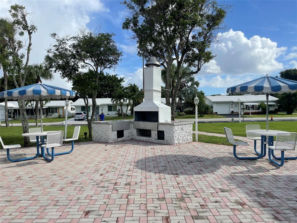2701 East Golf Boulevard, Unit 2017 Pompano Beach, FL 33064 - Photo 25 of 26 a view of a chair and table in backyard of the house