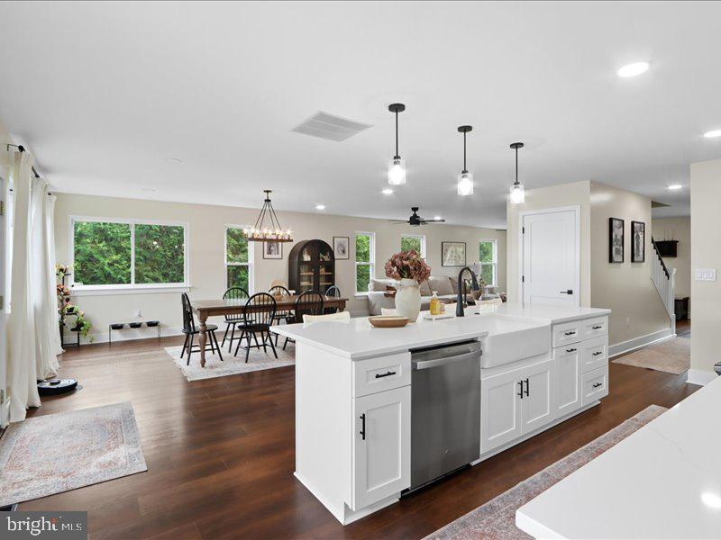 706 East Shore Road Pasadena, MD 21122 - Photo 18 of 32 a kitchen with stainless steel appliances kitchen island granite countertop a stove a sink a dining table and chairs with wooden floor