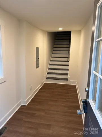 a view of a hallway with wooden floor and stairs