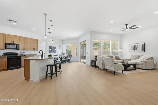 a view of a dining room with furniture a kitchen and chandelier