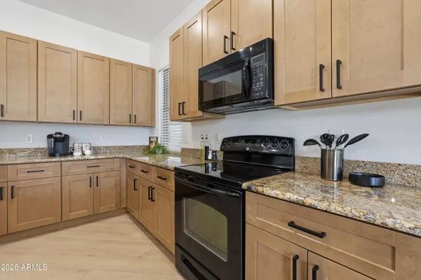 a kitchen with stainless steel appliances granite countertop a sink refrigerator and cabinets