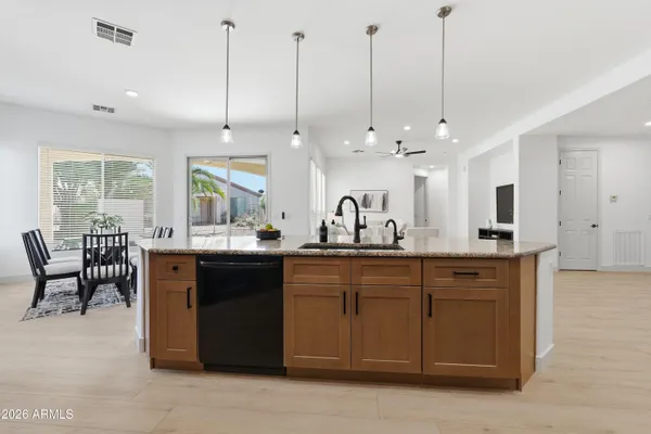 a kitchen with granite countertop white cabinets sink and stainless steel appliances