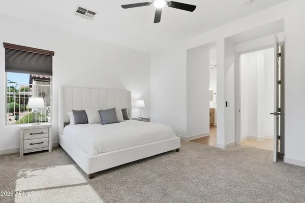 a spacious bedroom with a large bed and a large window