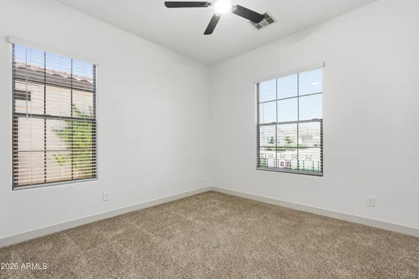 a spacious bedroom with a large bed and flat tv screen on dresser