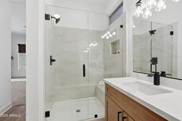 a spacious bathroom with double sink and a mirror a shower