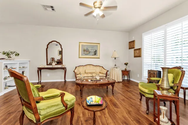 a living room with furniture kitchen view and a wooden floor
