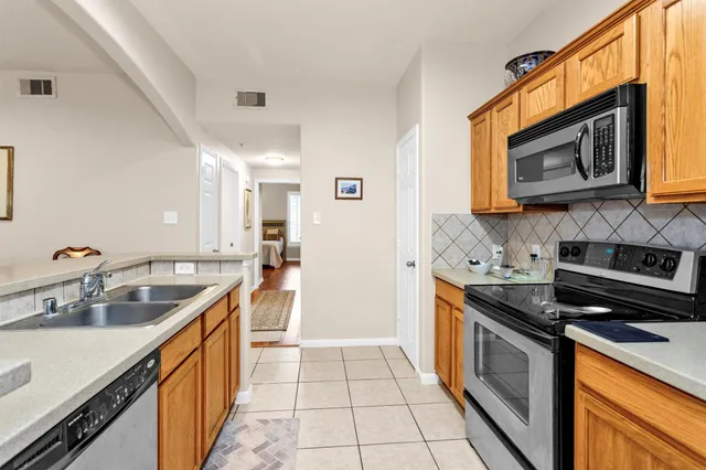 a kitchen with granite countertop a refrigerator stove and microwave