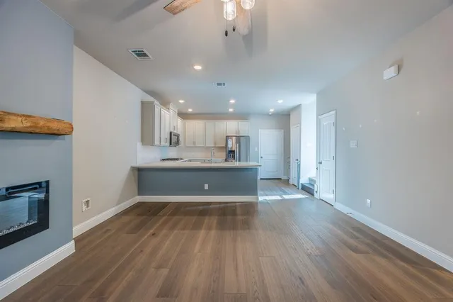 a view of kitchen with wooden floor and electronic appliances