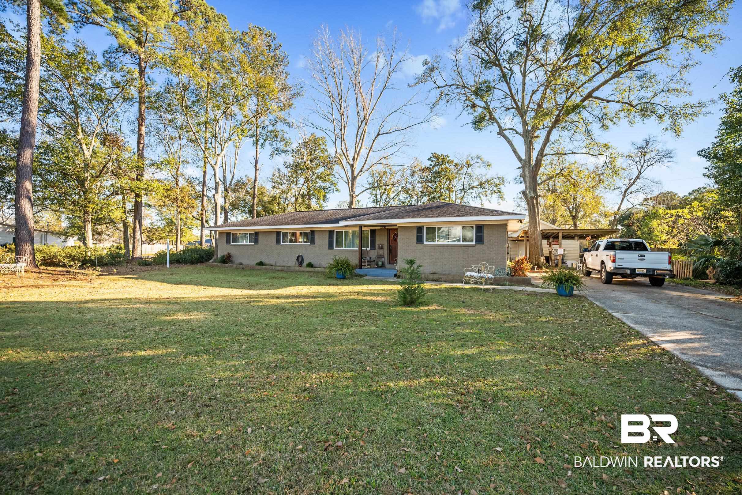 401 West Myrtle Avenue Foley, AL 36535 - Photo 3 of 39 Ranch-style home featuring a front yard, concrete driveway, and brick siding
