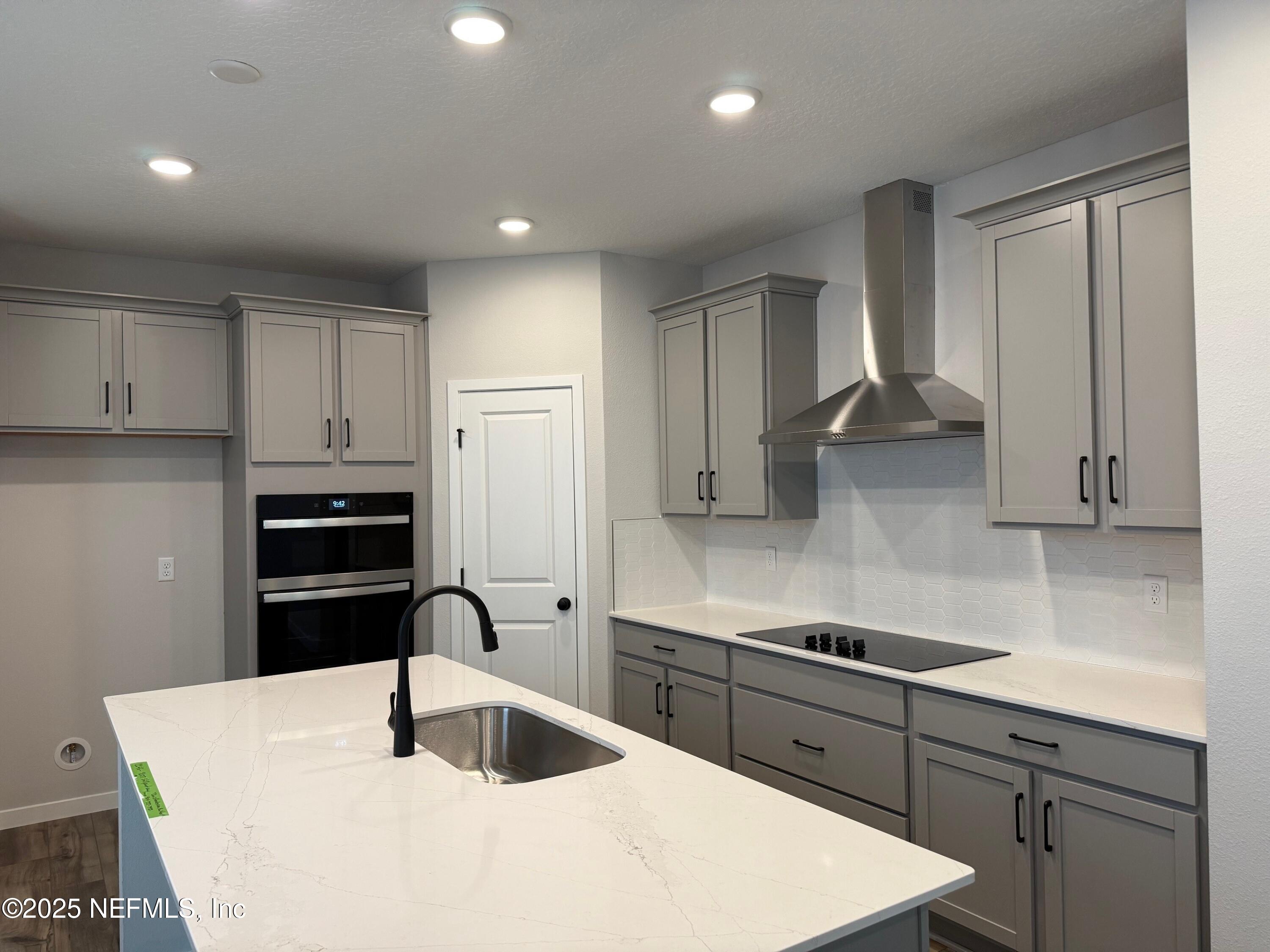 96517 Stillpoint Way Fernandina Beach, FL 32034 - Photo 3 of 9 a kitchen with granite countertop a sink stainless steel appliances and cabinets