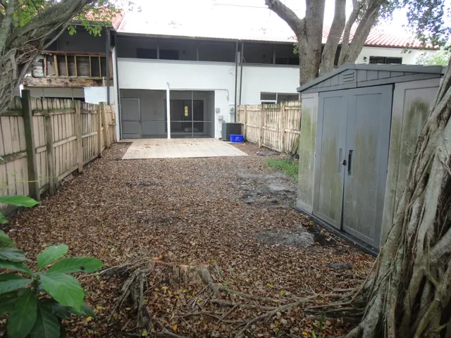 a view of a house with a yard and a large tree