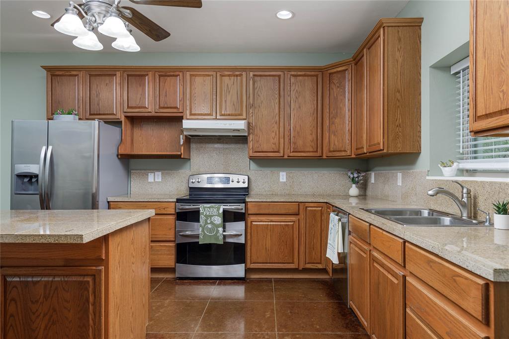 1878 North Lincoln Park Road Van Alstyne, TX 75495 - Photo 8 of 32 a kitchen with stainless steel appliances granite countertop a sink stove microwave and refrigerator