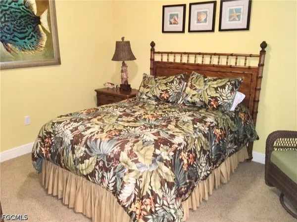 a bed sitting in a bedroom next to a lamp