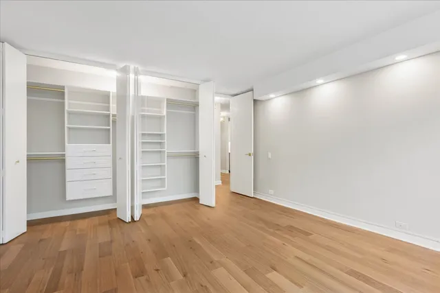 a view of an empty room with a closet and wooden floor