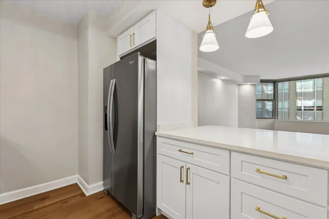 a kitchen with stainless steel appliances a refrigerator and wooden floor