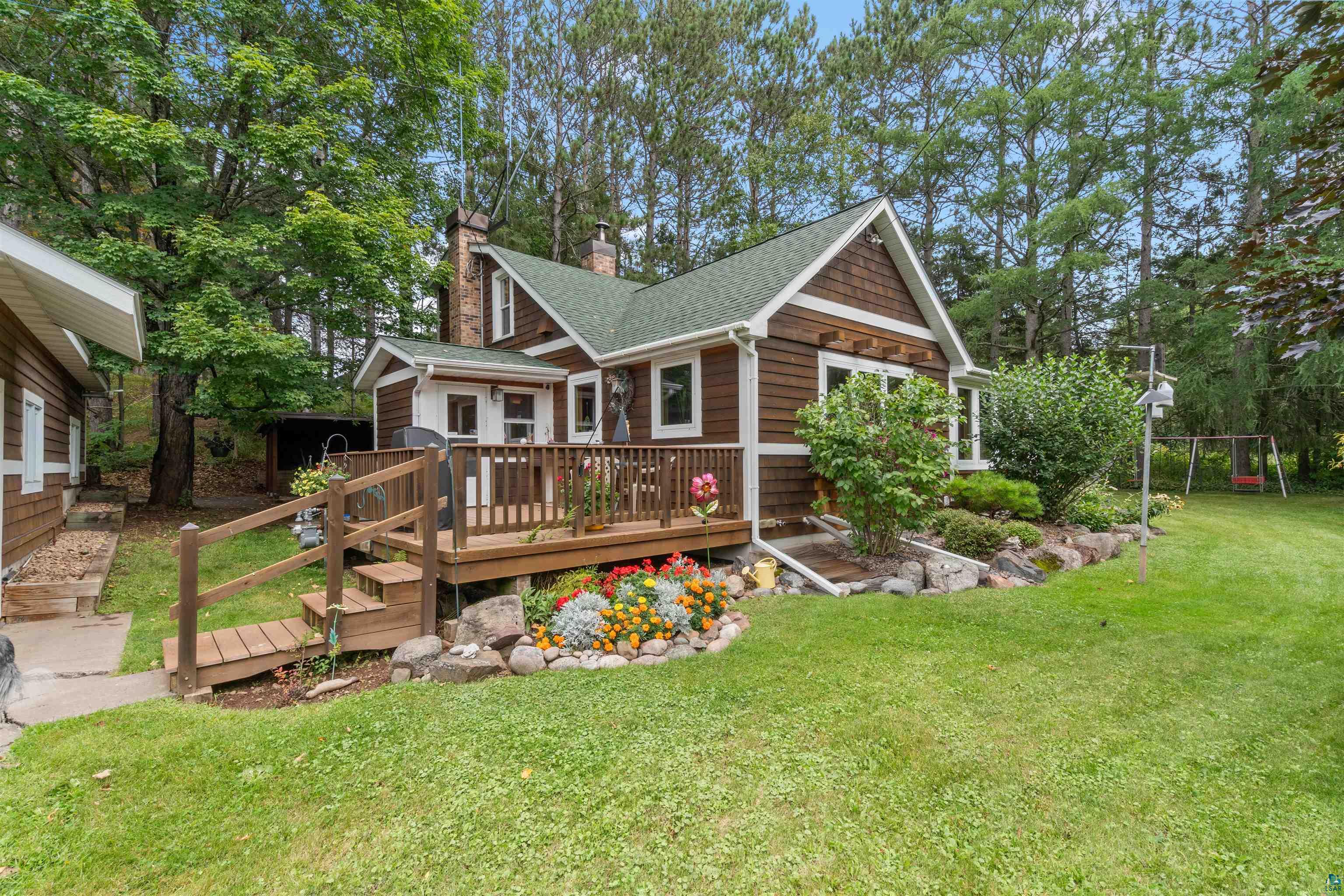 4793 Anderson Road Hermantown, MN 55811 - Photo 1 of 39 Cottage-style home featuring shingle siding, a front deck with railings, and a stone chimney