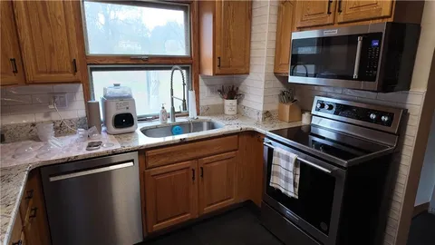 a kitchen with stainless steel appliances a sink stove and microwave