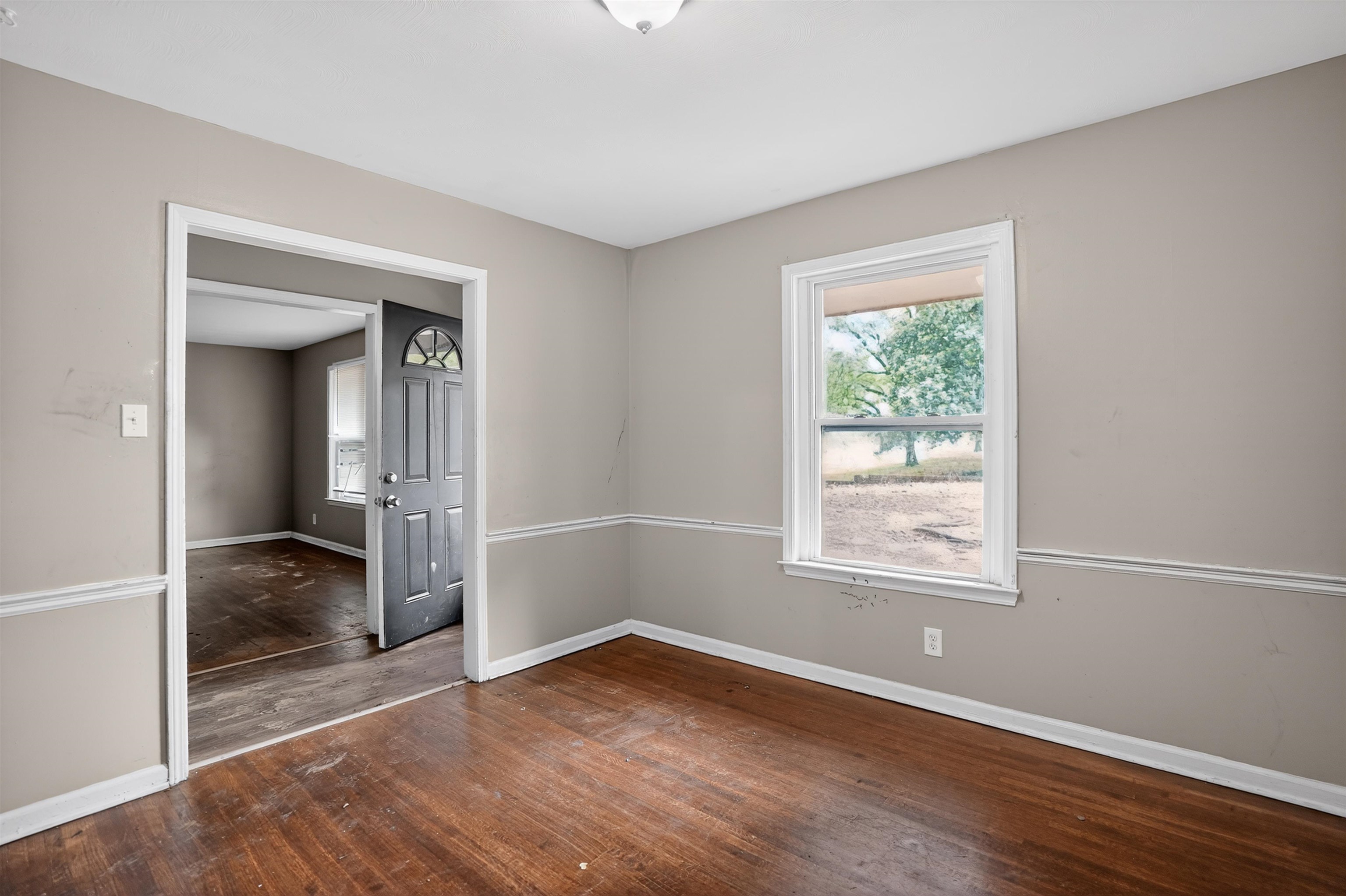 1890 Pennel Road Memphis, TN 38116 - Photo 14 of 25 Interior room featuring wood-finish flooring, light gray painted walls with chair rail molding, and a white-trimmed window