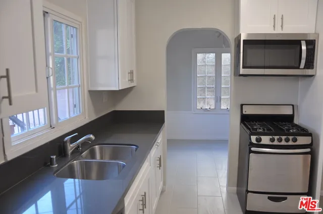 a kitchen with granite countertop a sink and a stove top oven