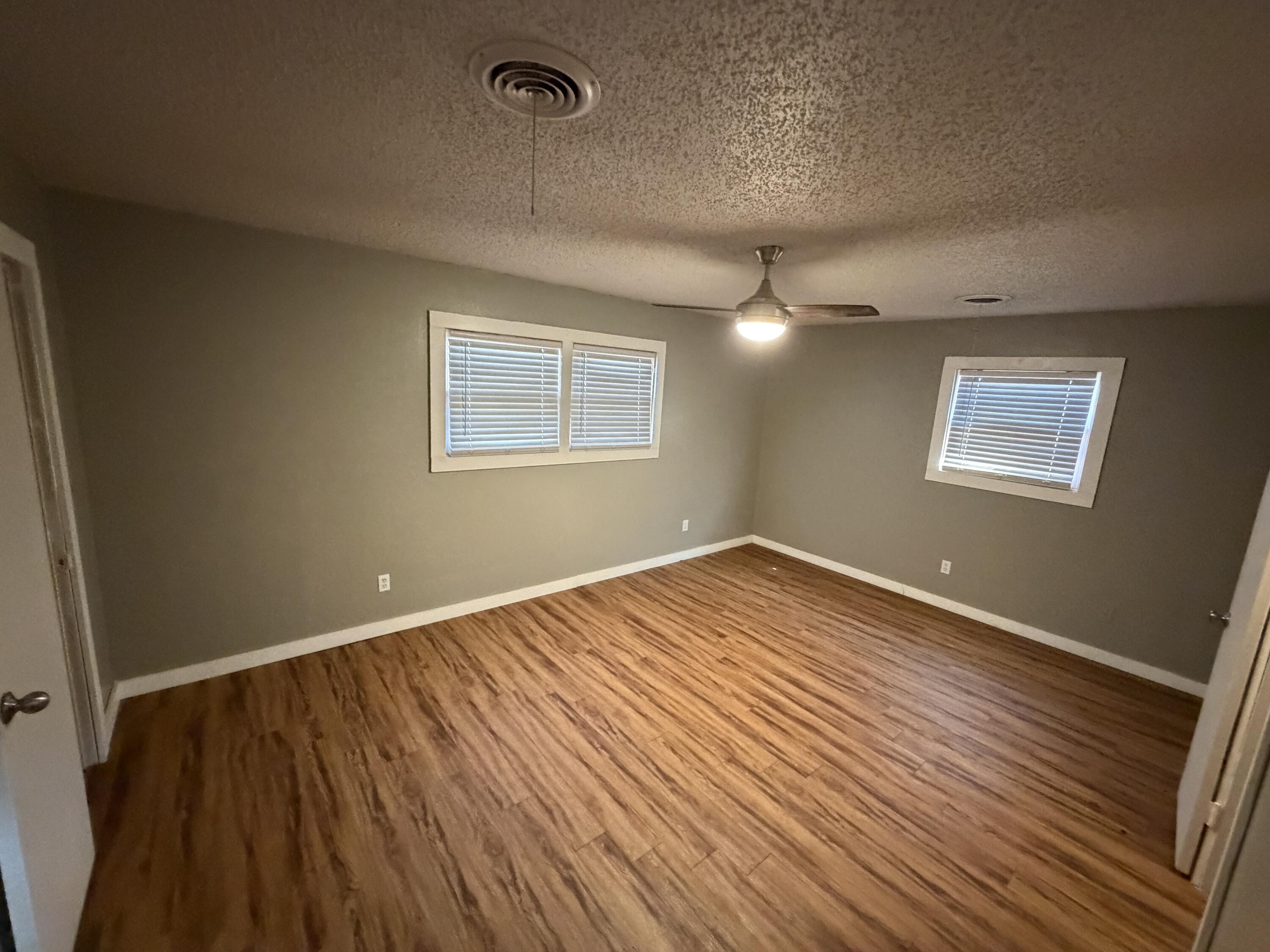 2010 52nd Street Lubbock, TX 79412 - Photo 11 of 13 an empty room with wooden floor and windows
