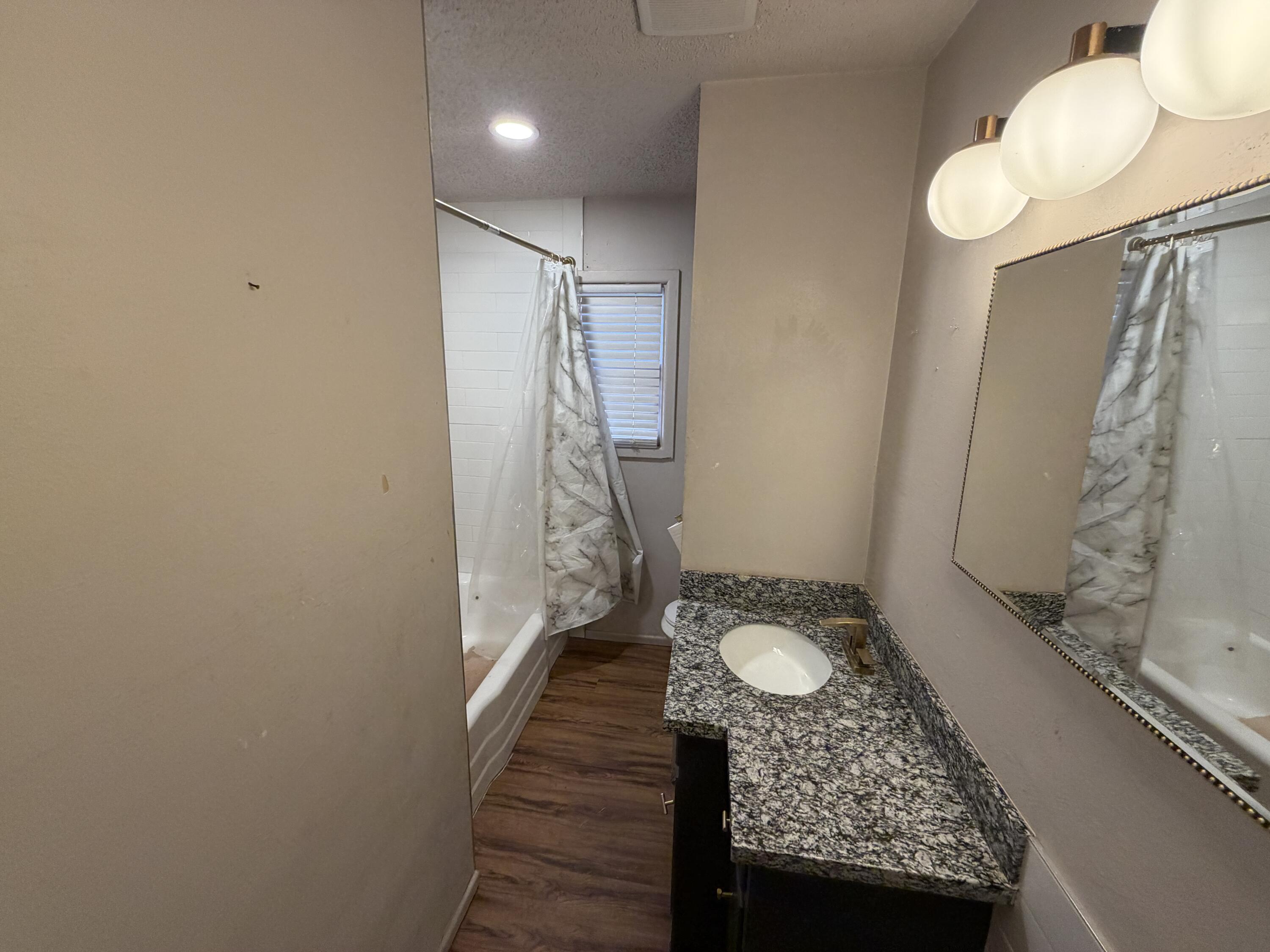 2010 52nd Street Lubbock, TX 79412 - Photo 12 of 13 a bathroom with a granite countertop sink a mirror and shower