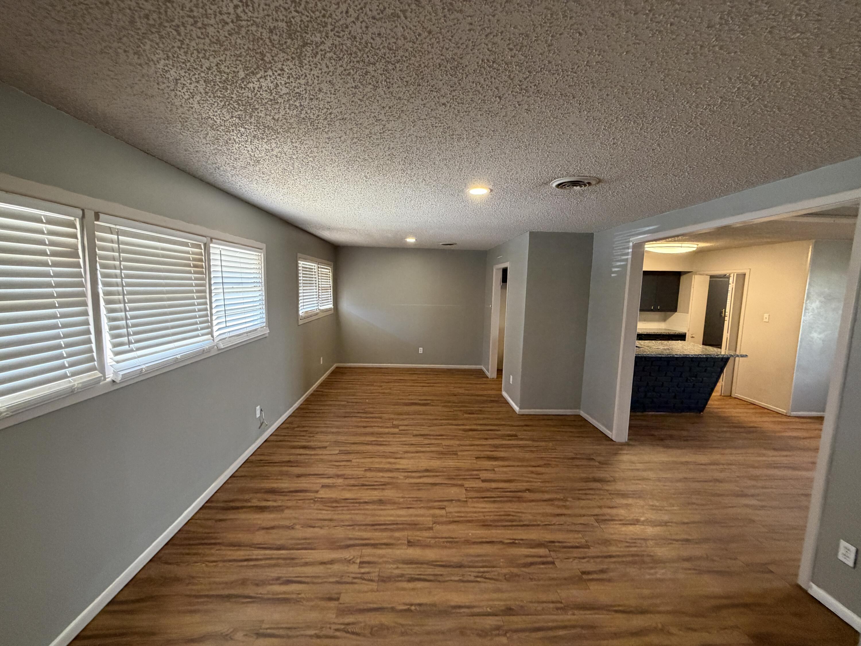 2010 52nd Street Lubbock, TX 79412 - Photo 2 of 13 a view of an empty room with wooden floor and a window