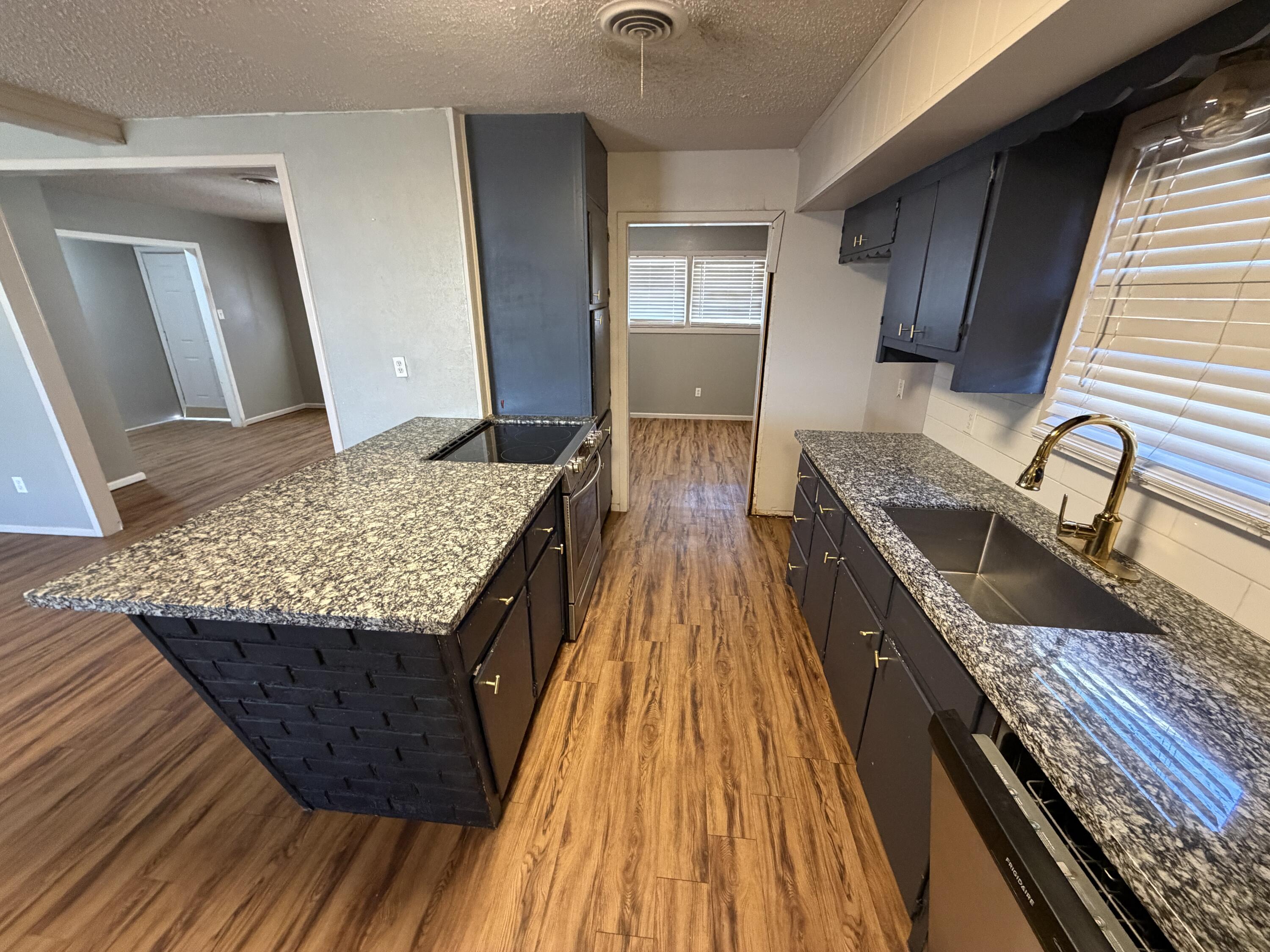 2010 52nd Street Lubbock, TX 79412 - Photo 3 of 13 a kitchen with granite countertop wooden cabinets and granite counter tops