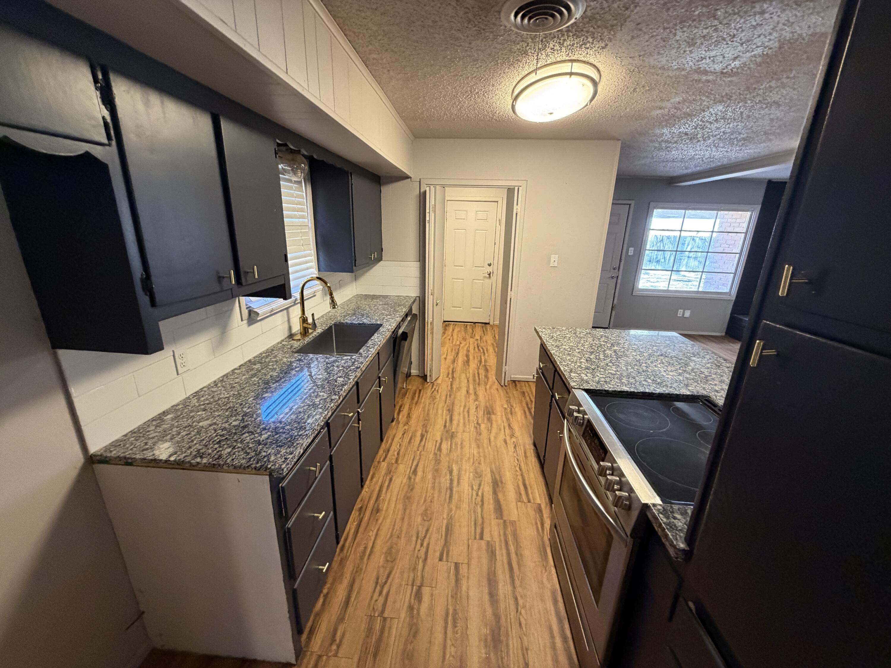 2010 52nd Street Lubbock, TX 79412 - Photo 4 of 13 a bathroom with a granite countertop sink a vanity and mirror