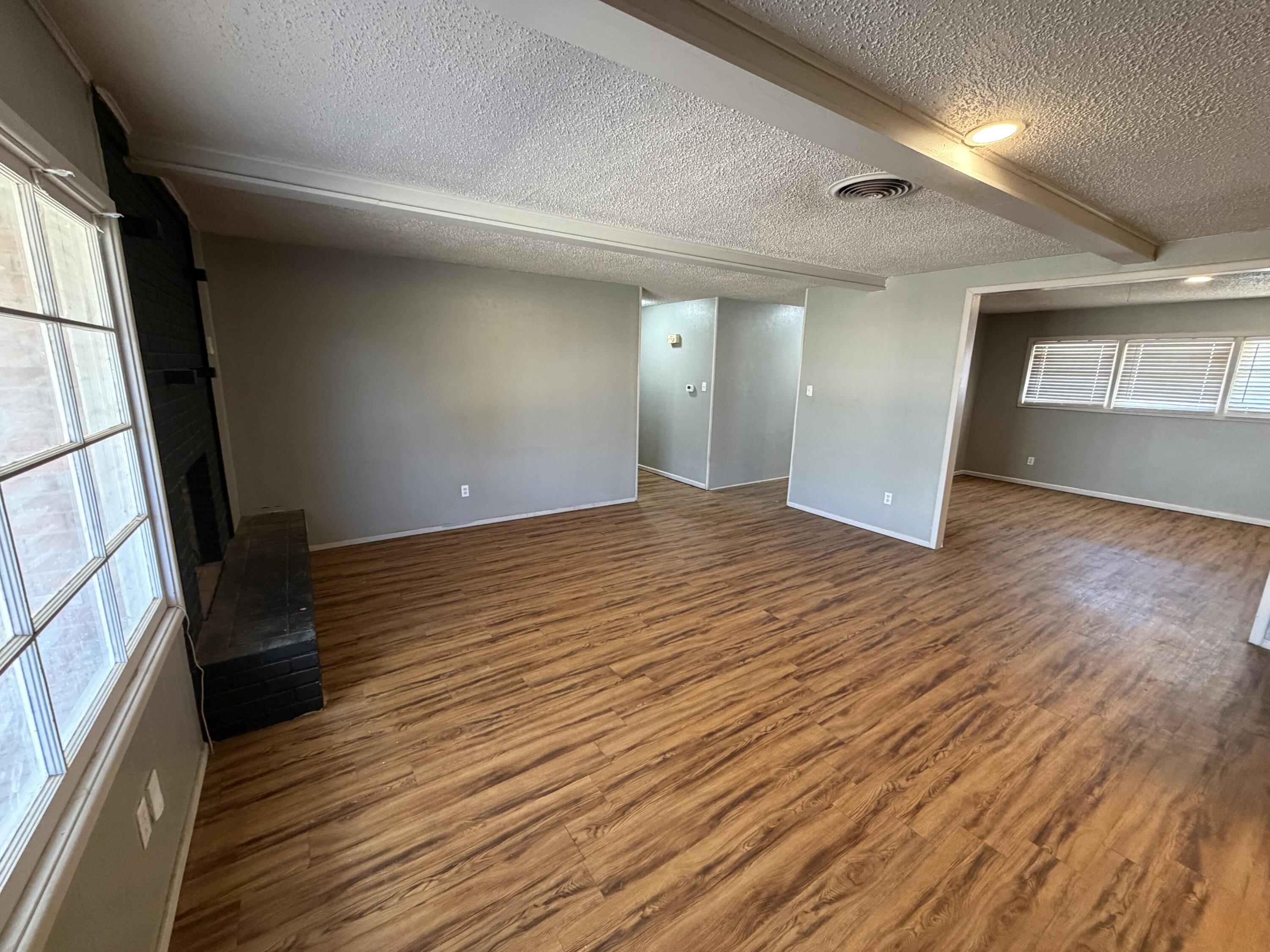 2010 52nd Street Lubbock, TX 79412 - Photo 5 of 13 an empty room with wooden floor and windows