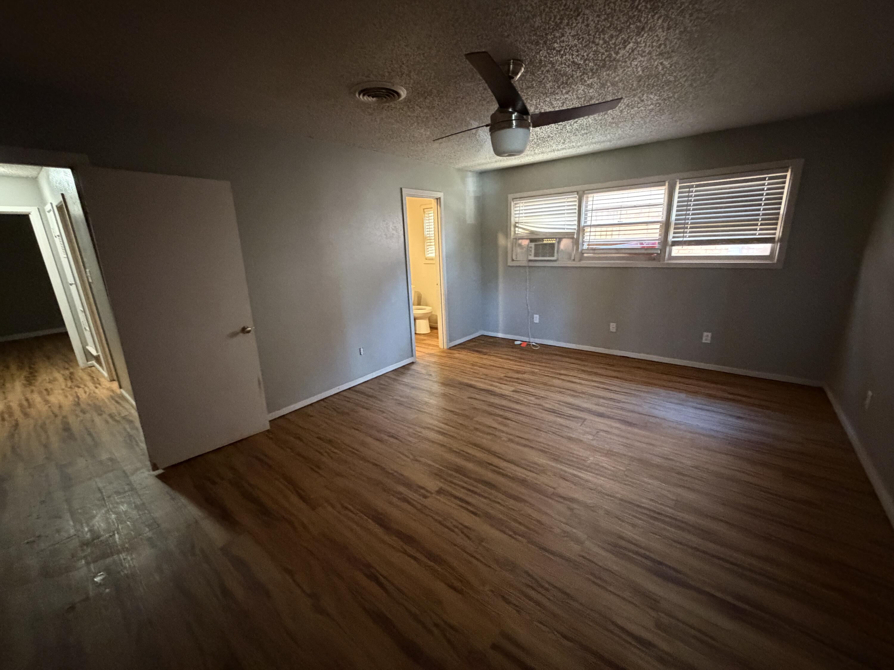 2010 52nd Street Lubbock, TX 79412 - Photo 8 of 13 a view of an empty room with wooden floor and a window