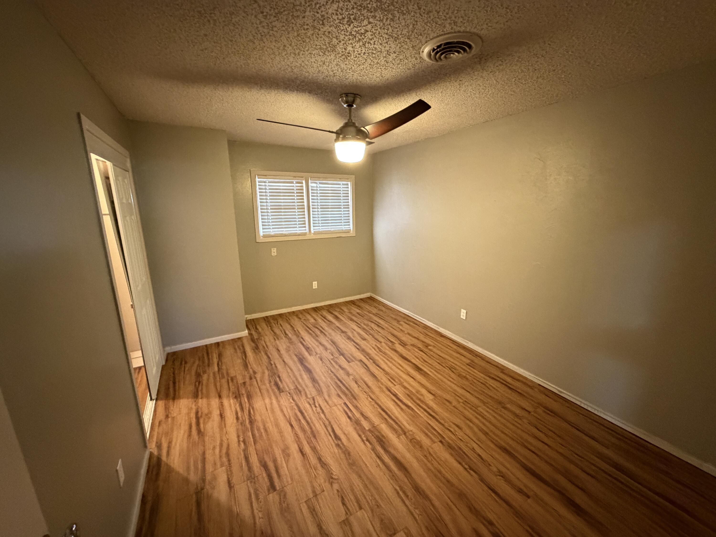 2010 52nd Street Lubbock, TX 79412 - Photo 9 of 13 an empty room with wooden floor and windows
