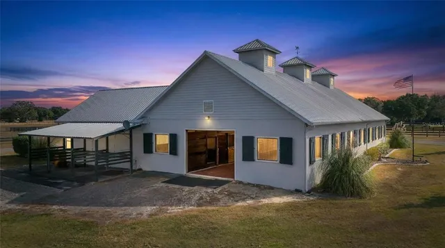 a kitchen with stainless steel appliances granite countertop a stove top oven a sink dishwasher and white cabinets with wooden floor