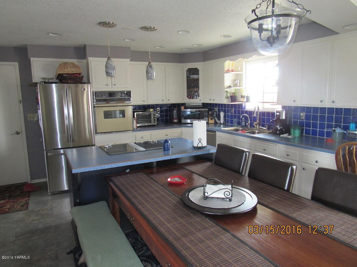 2841 McDonald Road Wapato, WA 98951 - Photo 5 of 11 a kitchen with a table chairs stove and refrigerator