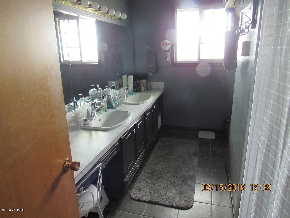 2841 McDonald Road Wapato, WA 98951 - Photo 7 of 11 a bathroom with a sink a mirror and a window