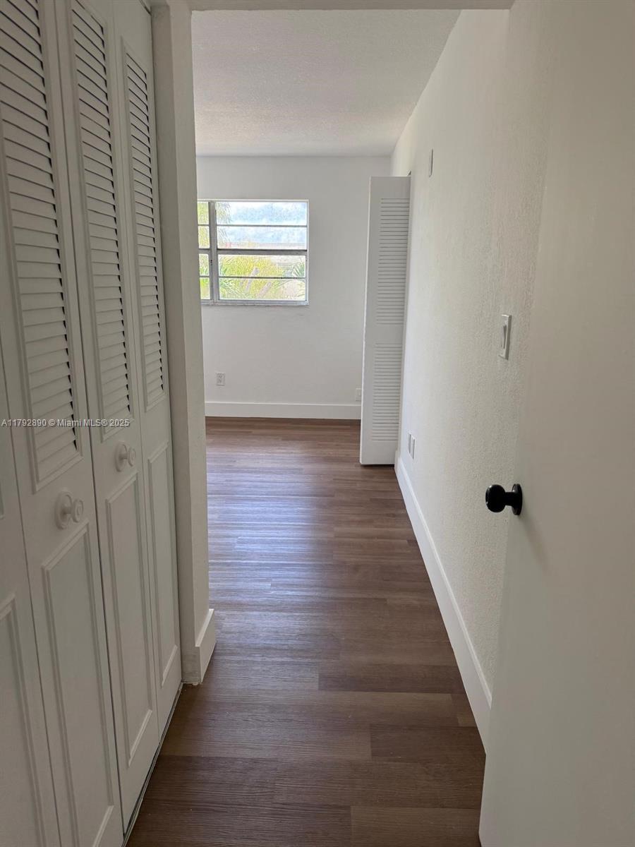 1350 West 53rd Street, Unit 33 Hialeah, FL 33012 - Photo 3 of 17 a view of a hallway with wooden floor and closet