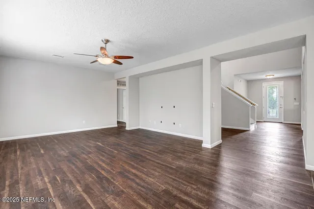 a view of a livingroom with wooden floor and a ceiling fan