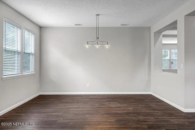 a view of a room with window wooden floor and chandelier