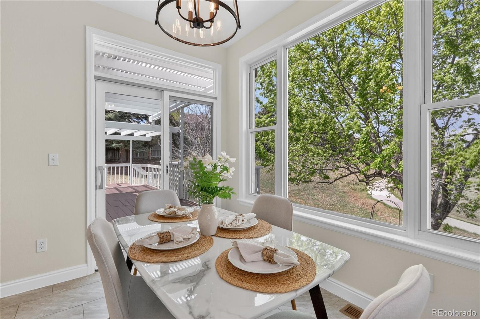 2445 East Lansdowne Court Highlands Ranch, CO 80126 - Photo 13 of 49 a dining room with furniture a large window and dining table