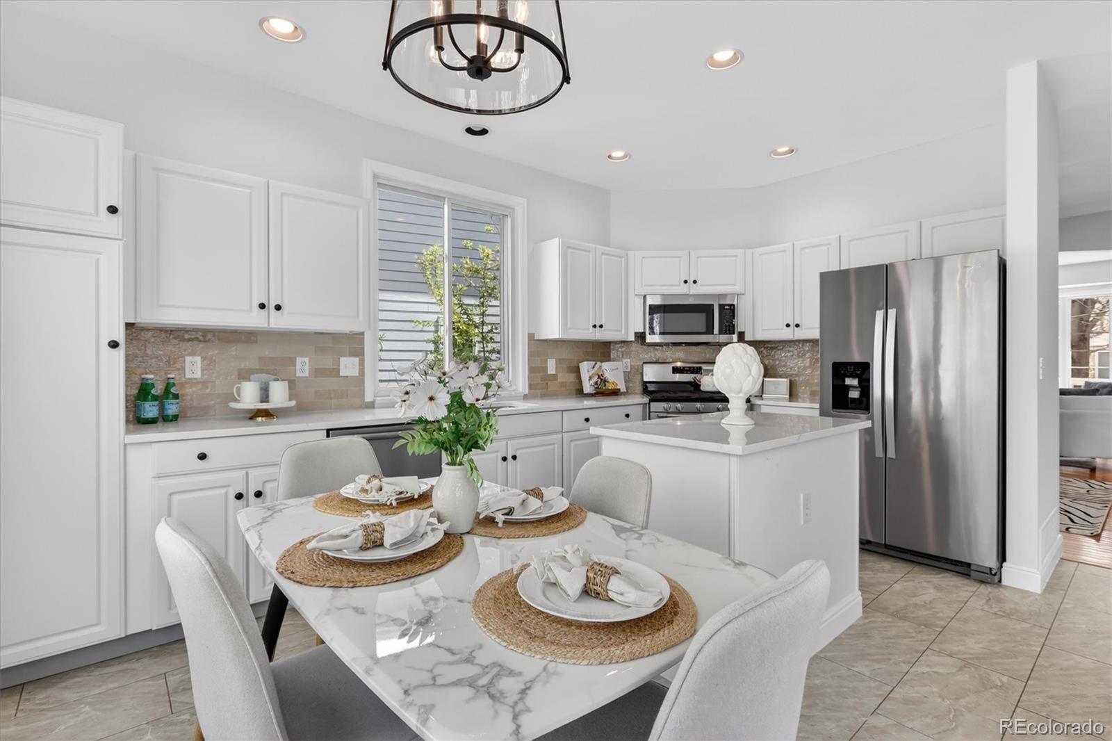 2445 East Lansdowne Court Highlands Ranch, CO 80126 - Photo 14 of 49 a open dining room with furniture a kitchen and chandelier